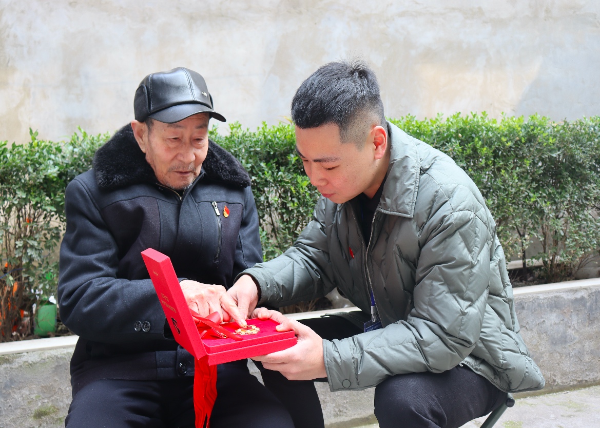 老黨員金知一展示“光榮在黨50年”紀(jì)念章 